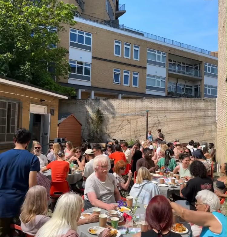Neighbours gathered around tables for a community dinner at the Ellingfort Road building